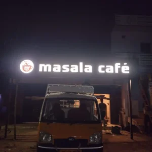 Masala Café illuminated name board glowing at night