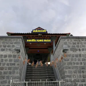 Illuminated name board at the entrance of a temple with Tamil text