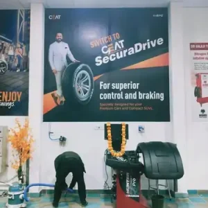 vehicle showroom indoor board displaying CEAT SecuraDrive tyre advertisement for premium cars